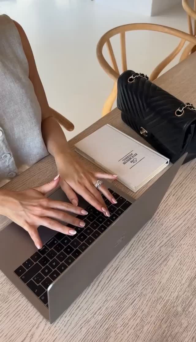 Typing on a laptop next to a journal, behind the scenes at Stardust